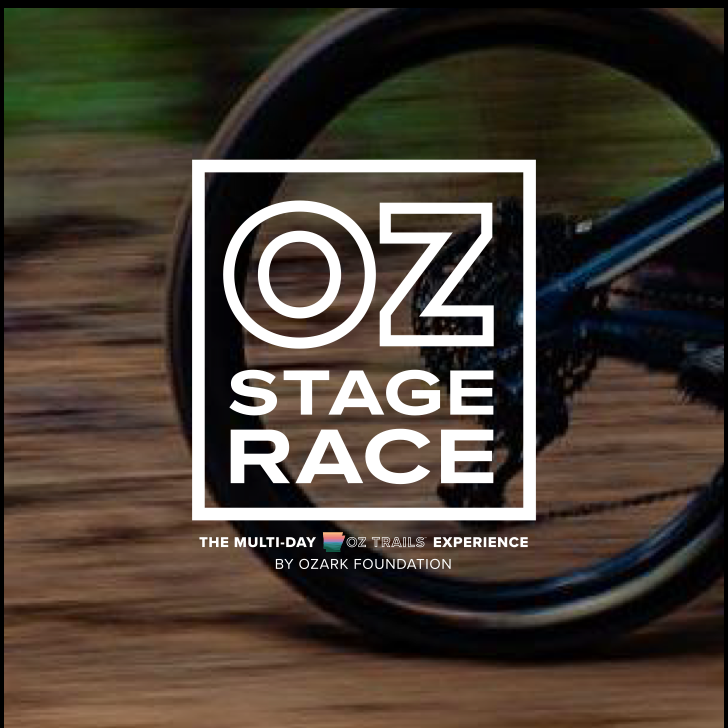 Oz Stage Race logo over a blurred photo of a bike wheel on trail